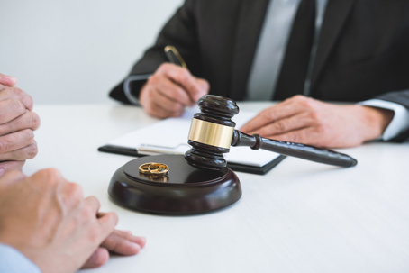couple signing divorce papers with a lawyer