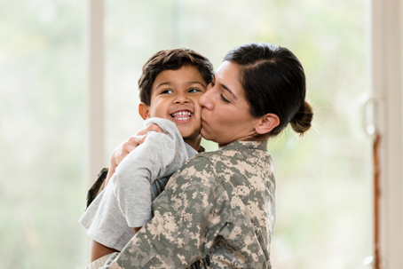 service member kissing son on the cheek