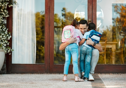 father hugging kids after school