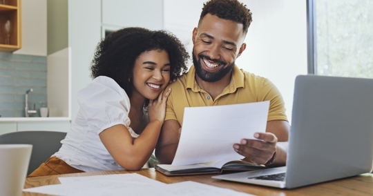 happy couple reading documents at home